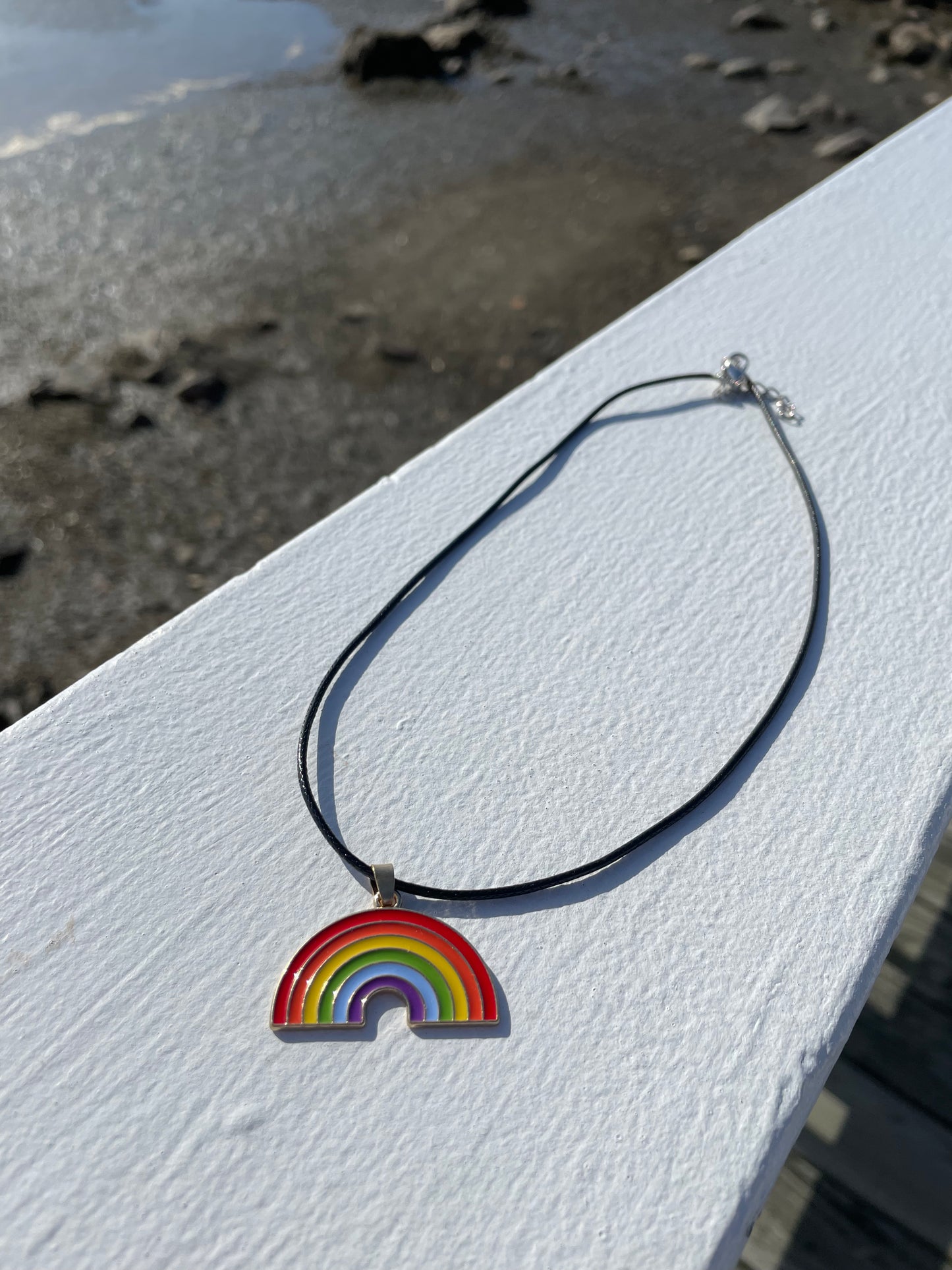 full rainbow necklace laid out on white railing