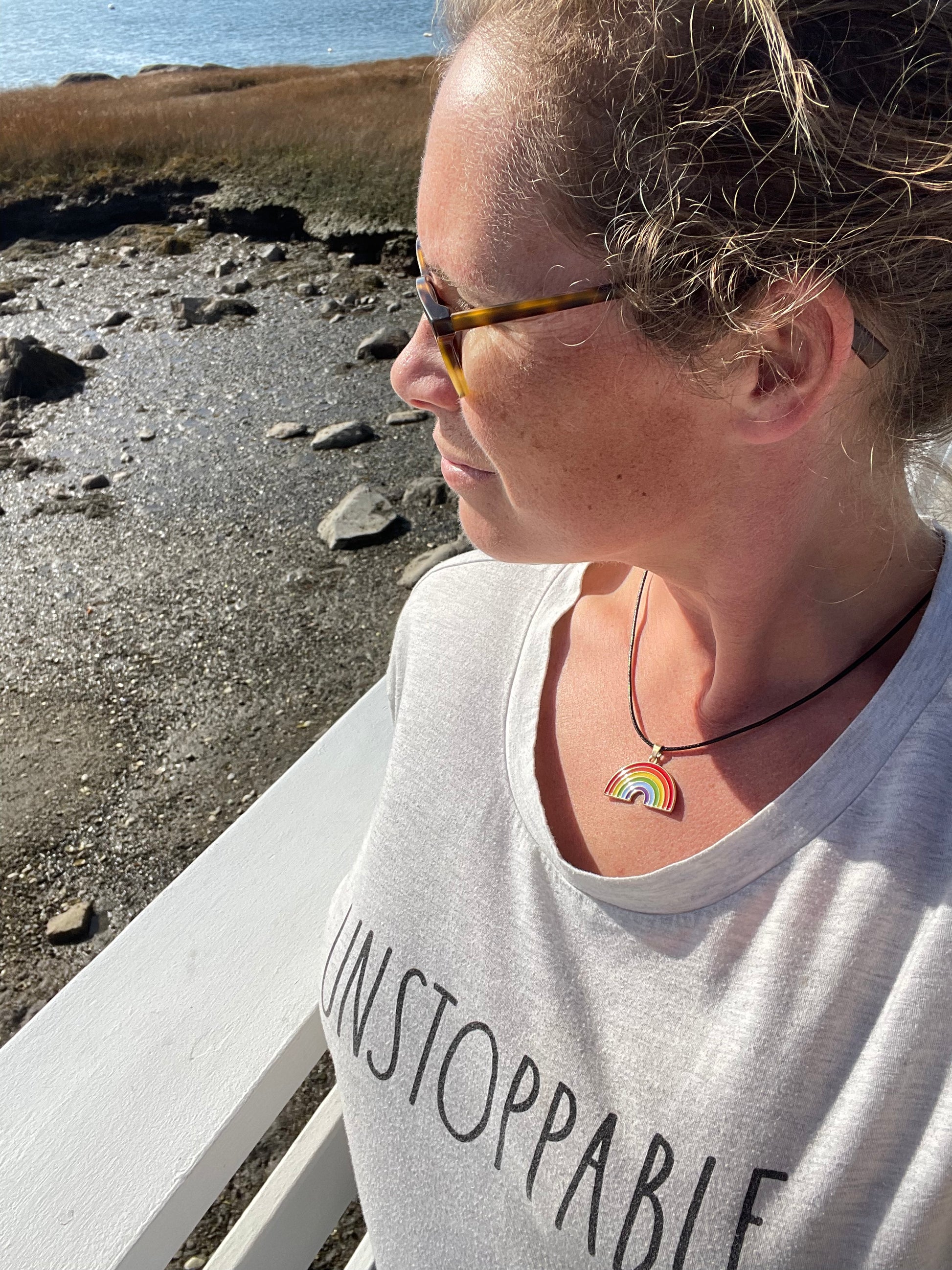 rainbow necklace shown with unstoppable shirt on person