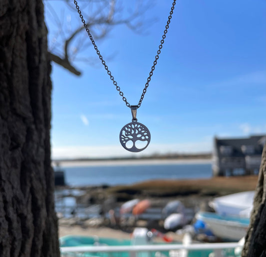 tree of life stainless steel necklace against blue sky
